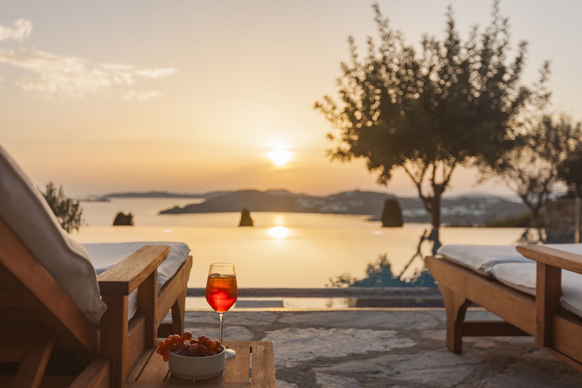 Sunset view on the poolside sunloungers at AGL Luxury Villas is one of the dauly things to do on your Mykonos honeymoon.