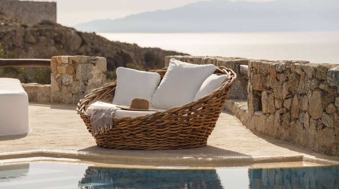 Comfy seat on the terrace by the pool of Villa Daphne, one the best luxury villas in Mykonos, Greece.
