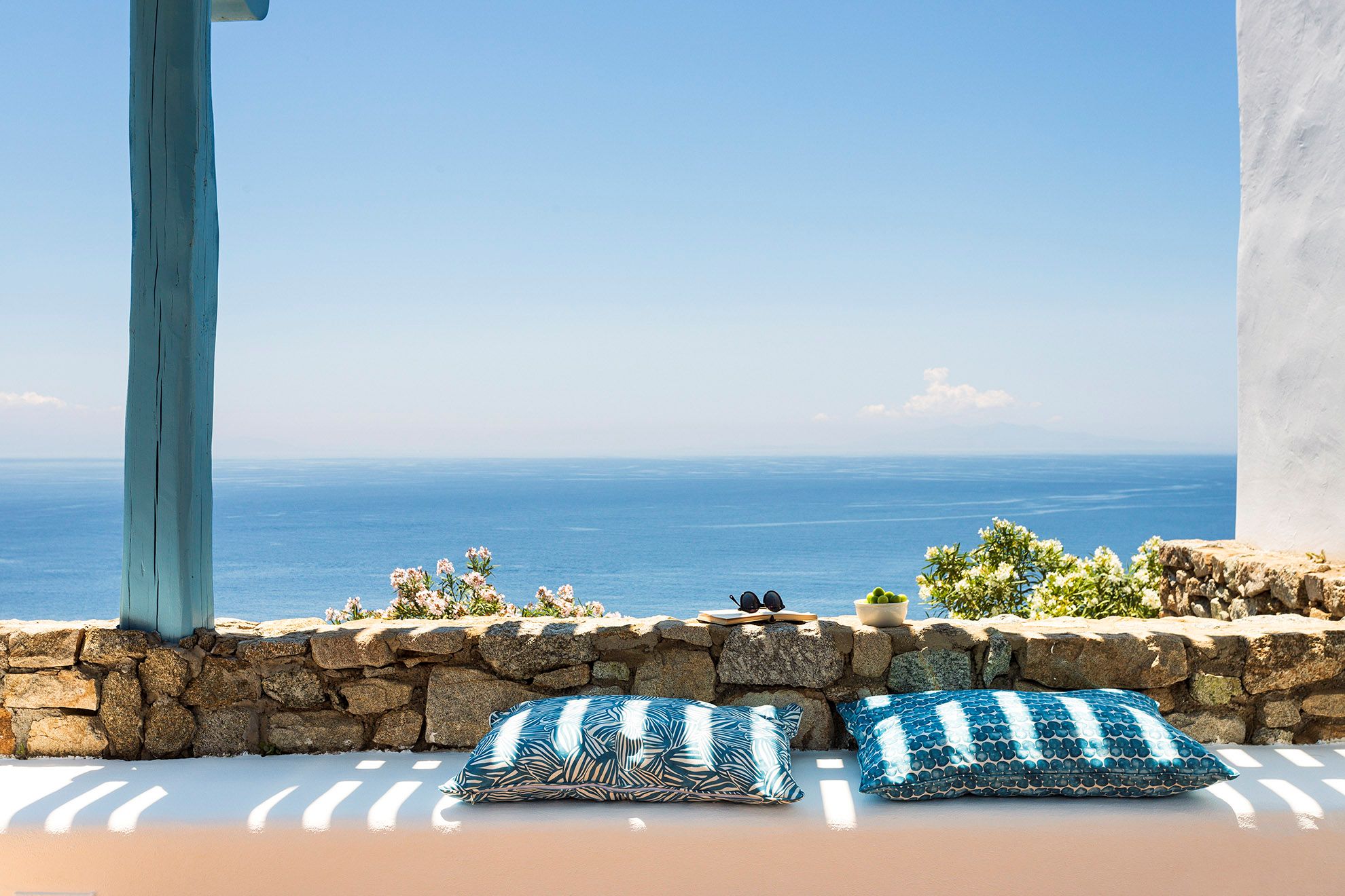 Overlooking the endless blue of the Aegean, atop the cliffs of Agios Lazaros, above one of the most quiet beaches in Mykonos.